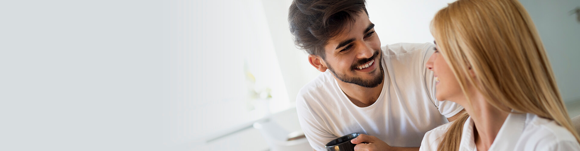 Seguros de Ahorro - Pareja joven feliz y enamorados en pijama, utilizando la tablet tumbados en el sofa de casa buscando seguros de ahorro Seguros de Ahorro - Pareja joven feliz y enamorados en pijama, utilizando la tablet tumbados en el sofa de casa buscando seguros de ahorro