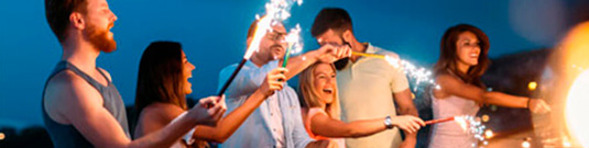 Jóvenes de fiesta en una playa con bengalas Jóvenes de fiesta en una playa con bengalas