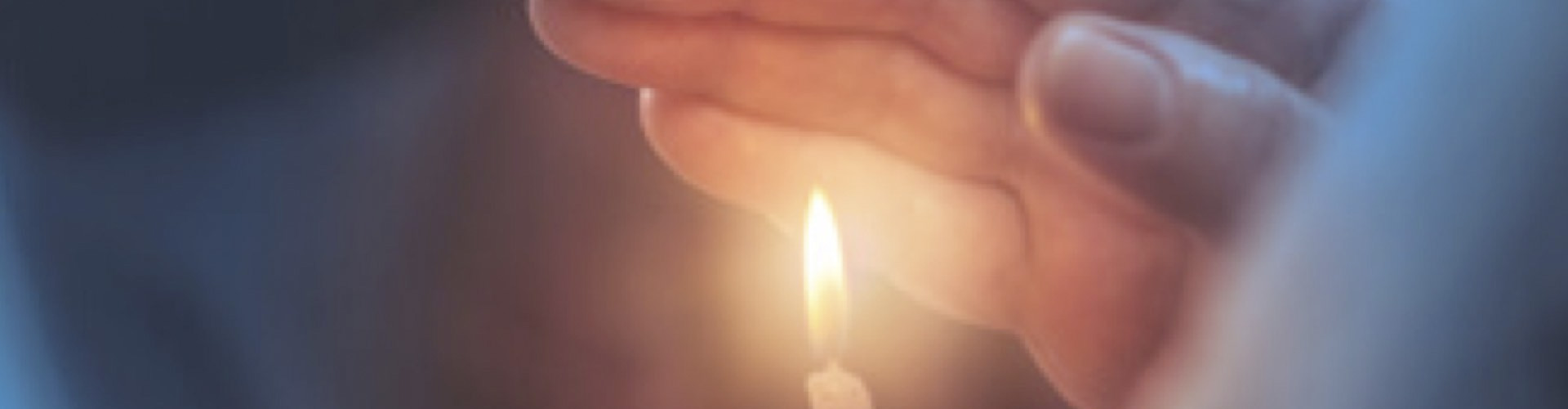 Soluciones Entidades Religiosas cabecera - Mano agarrando una vela encendida - Caja Rural de Navarra