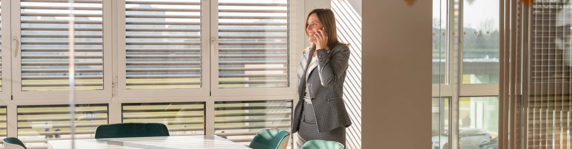 Pagos Empresas - Mujer con traje hablando por el móvil en una oficina - Caja Rural de Navarra