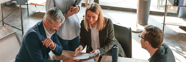 Rural Factoring -Un hombre y dos mujeres hablando en una reunión en la oficina Rural Factoring -Un hombre y dos mujeres hablando en una reunión en la oficina