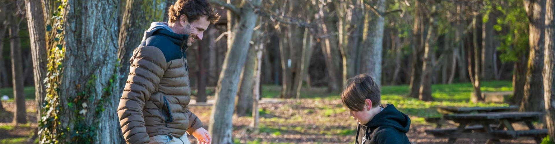 Seguros particulares - padre e hijo jugando con un balón en el parque - Caja Rural de Navarra