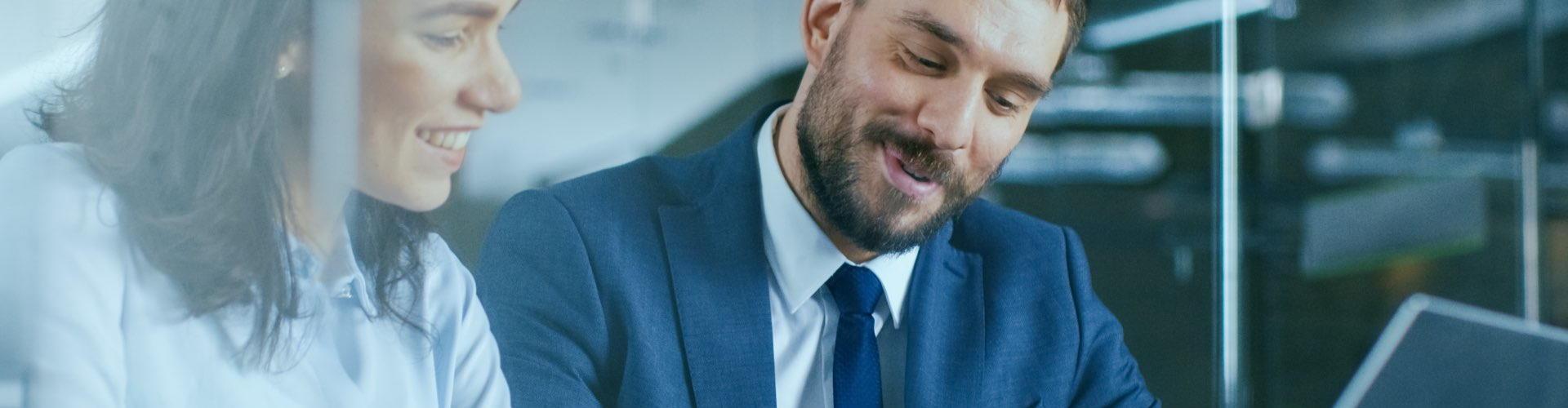 Gestión de Tesorería - Hombre de traje y mujer con camisa sonriendo - Caja Rural de Navarra