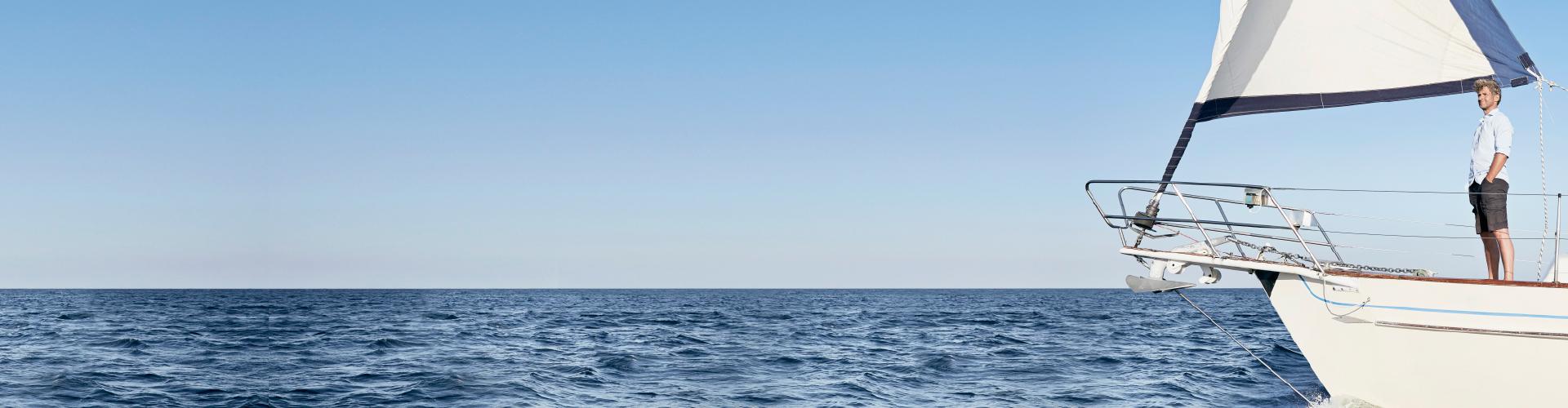hombre-de-pie-en-su-velero-admirando-el-mar-tranquilamente.-navegar.-tranquilidad-