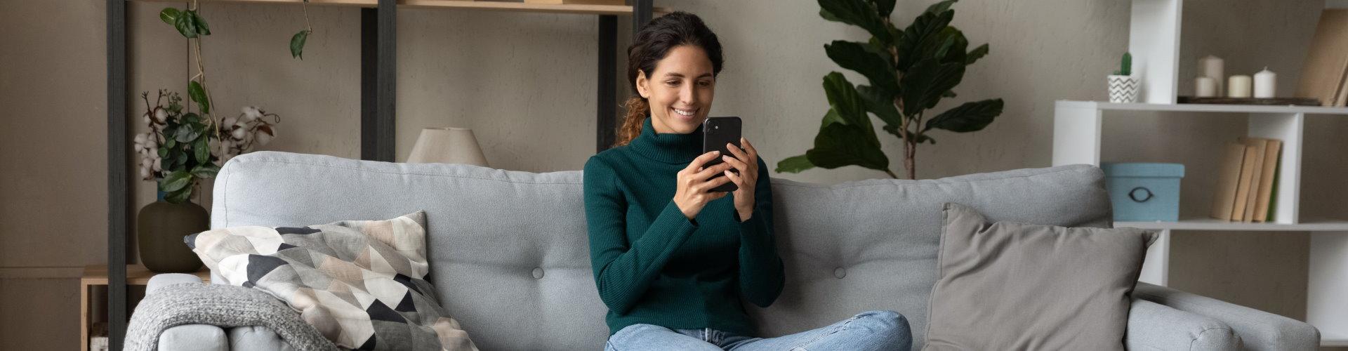bolsa-y-mercado-mujer-operando-en-bolsa-ruralvia-desde-el-sofa-por-el-movil