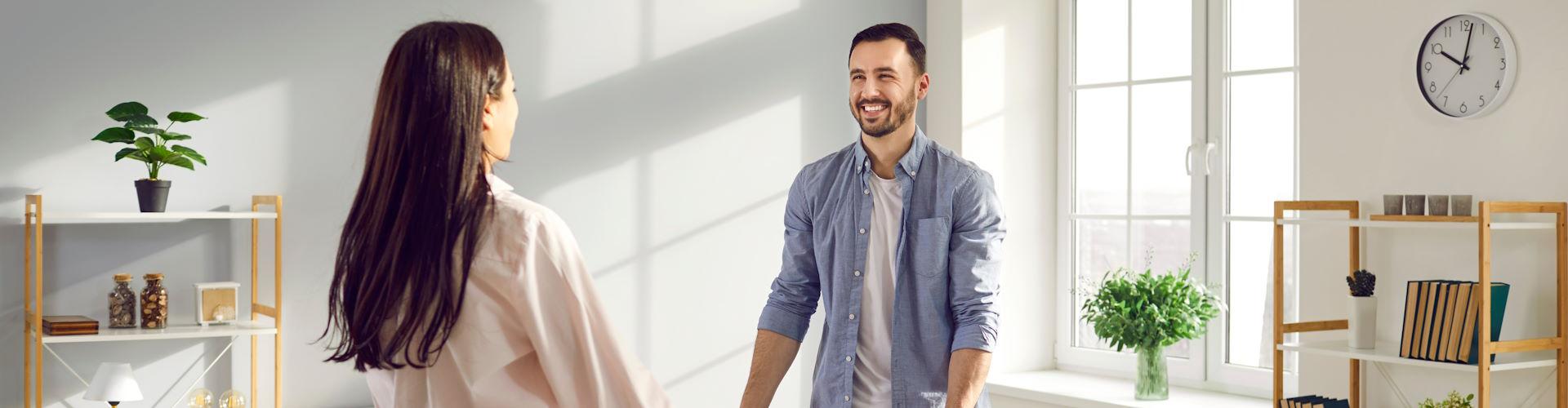 Pareja cargando un sofá en su casa