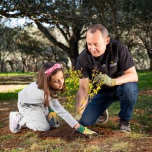 Padre e hija plantando árbol
