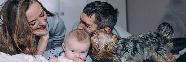 Préstamo Nomina - Padre y madre con bebe y perro sonriendo