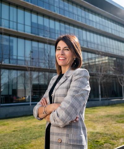 Mujer de negocios sonriendo frente a edificio de oficinas  - Caja Rural de Navarra